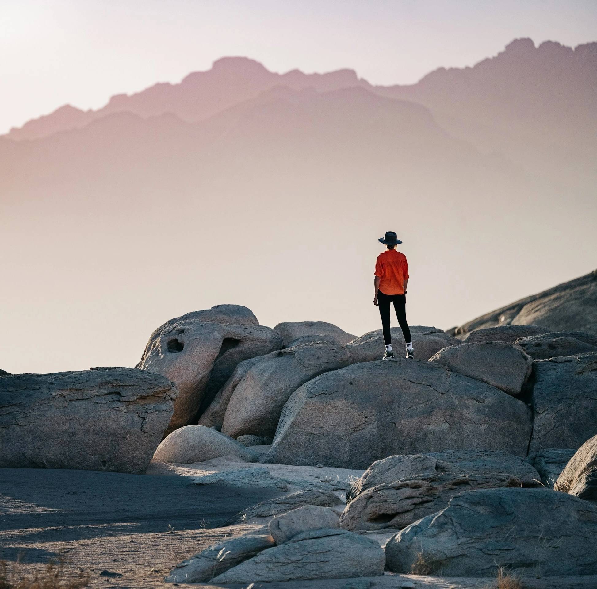Woman standing on rocks looking at the horizon